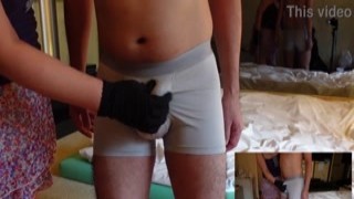 a girl who presses the tip of her penis against the bottom of her pants and slaps her hand against her chest repeatedly